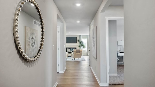 corridor with recessed lighting, wood finished floors, visible vents, and baseboards