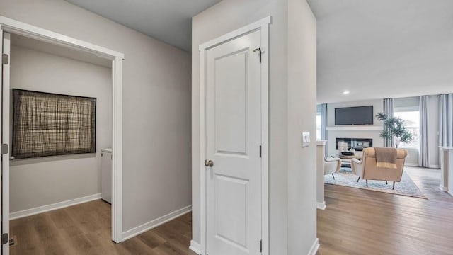 hallway with baseboards, wood finished floors, and recessed lighting