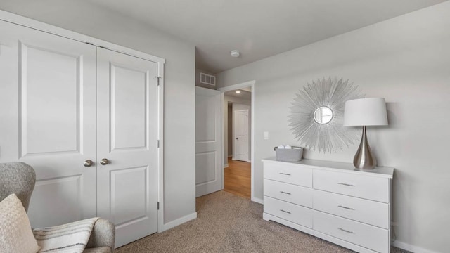 living area featuring visible vents, light carpet, and baseboards