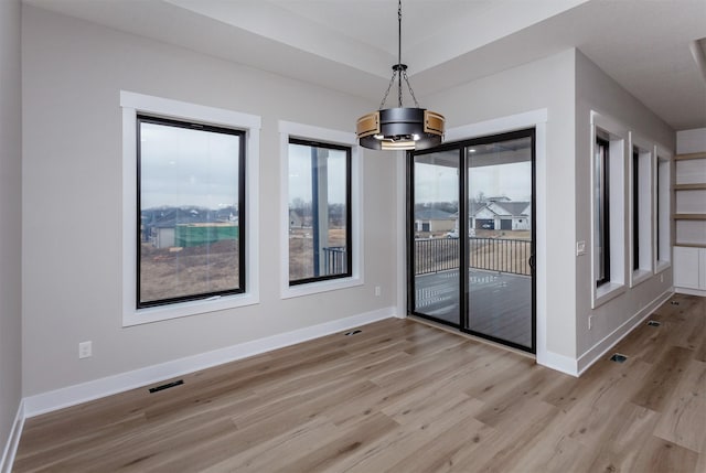 unfurnished room with visible vents, baseboards, and wood finished floors