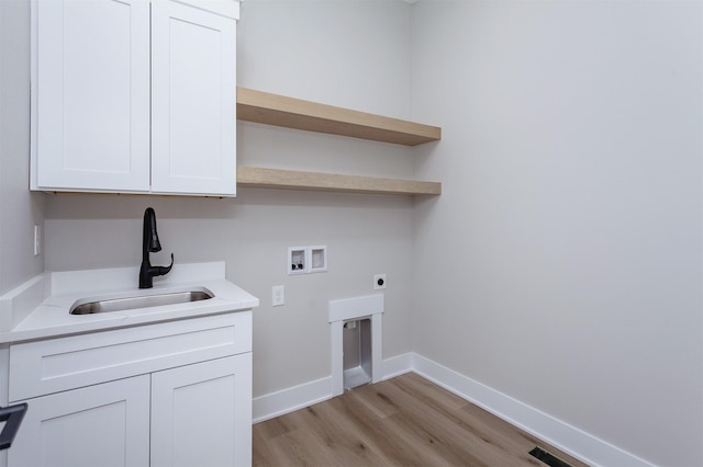 laundry room with hookup for an electric dryer, washer hookup, a sink, baseboards, and light wood-type flooring