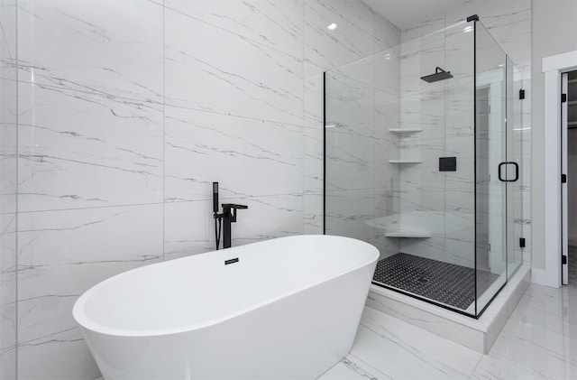 bathroom featuring marble finish floor, a shower stall, and a soaking tub