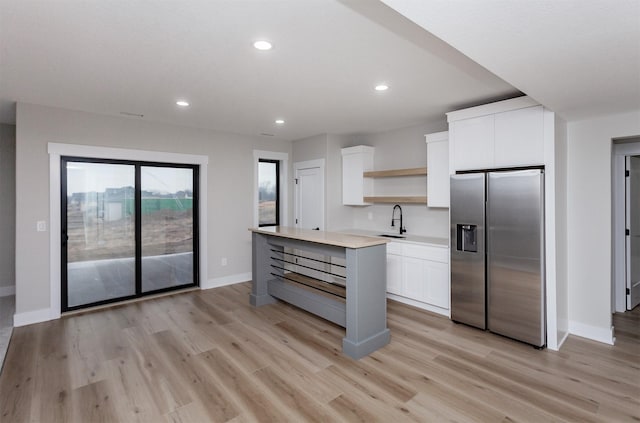 4744 144th St, Urbandale, IA 50323 - kitchen featuring stainless steel fridge, open shelves, light countertops, light wood-style floors, and recessed lighting