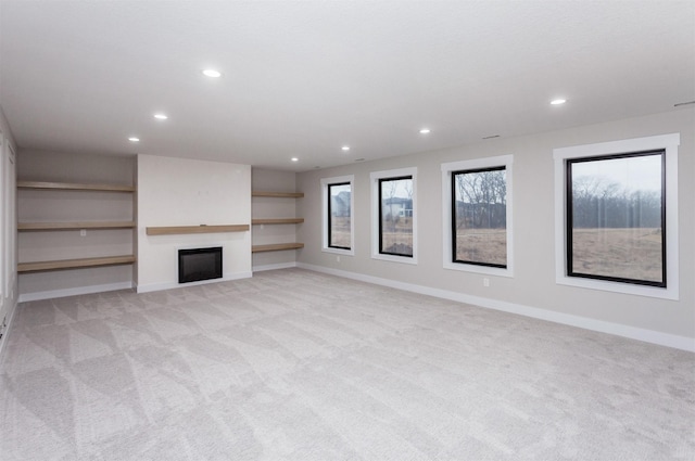unfurnished living room with light carpet, recessed lighting, a fireplace, and baseboards