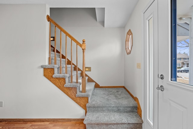 entrance foyer with stairway, wood finished floors, and baseboards