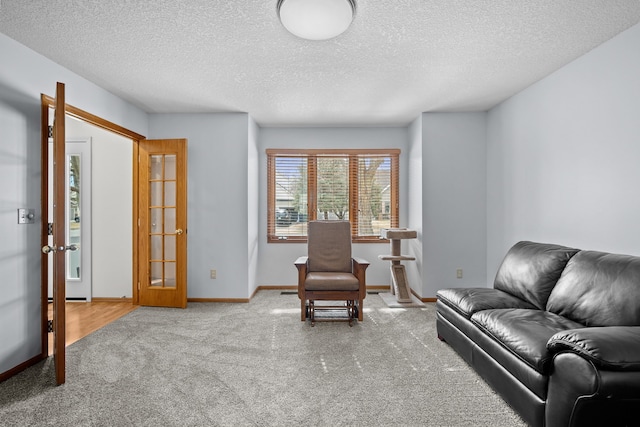 sitting room with french doors, a textured ceiling, baseboards, and carpet floors