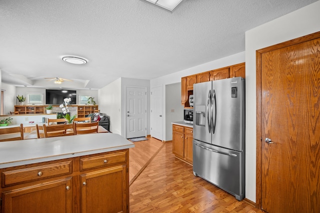 kitchen with light wood-style floors, ceiling fan, light countertops, and stainless steel appliances