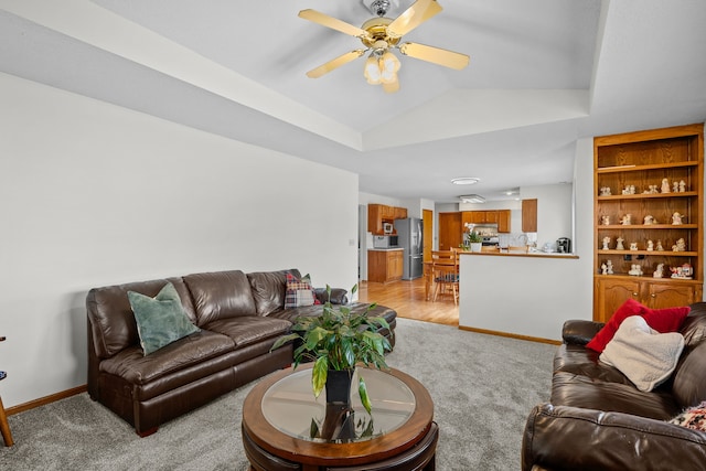 living room featuring baseboards, a ceiling fan, light carpet, and lofted ceiling