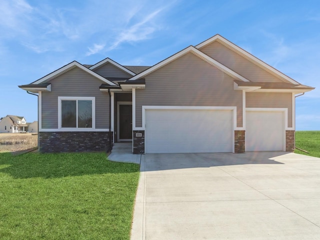 craftsman-style house featuring a garage, a front yard, stone siding, and driveway