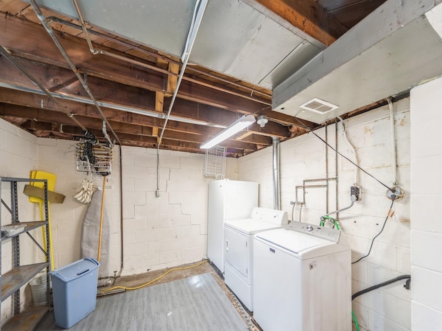 laundry area featuring laundry area, washer and clothes dryer, wood finished floors, and visible vents