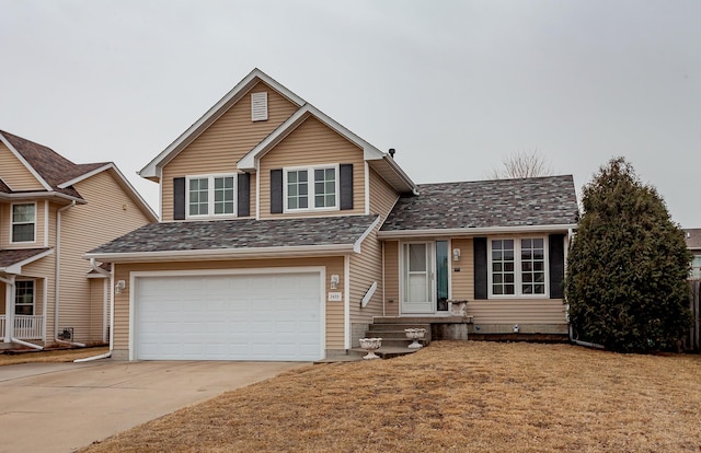 split level home with a front lawn, concrete driveway, and an attached garage