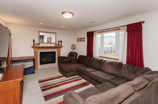 carpeted living area featuring a glass covered fireplace