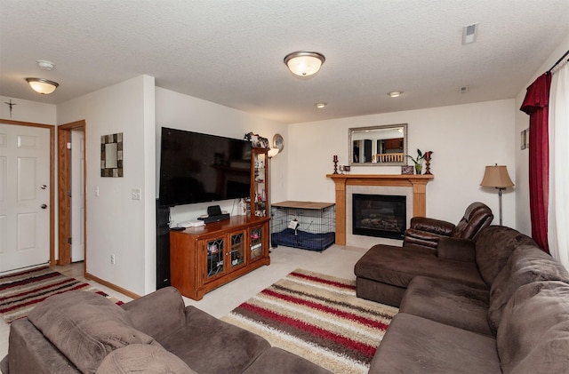 carpeted living area with visible vents, a fireplace, a textured ceiling, and baseboards