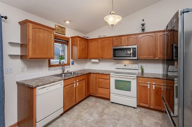 kitchen with lofted ceiling, a sink, appliances with stainless steel finishes, decorative light fixtures, and brown cabinets