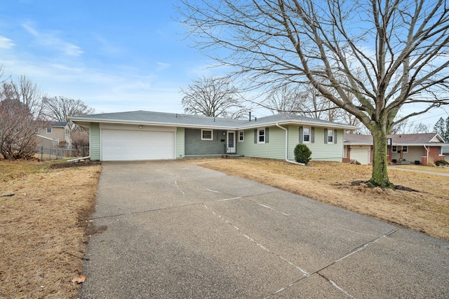 view of front of home with an attached garage, fence, and concrete driveway