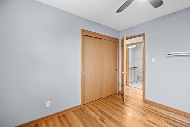 unfurnished bedroom with ceiling fan, light wood finished floors, a closet, and baseboards