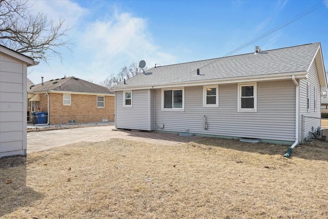 rear view of property featuring roof with shingles and fence