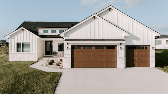 modern farmhouse style home featuring a garage, concrete driveway, roof with shingles, a front lawn, and board and batten siding