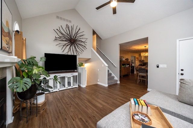 living room with visible vents, stairway, ceiling fan, vaulted ceiling, and wood finished floors