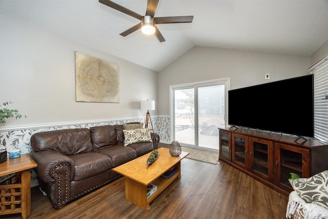 living area with a ceiling fan, vaulted ceiling, wood finished floors, and wainscoting