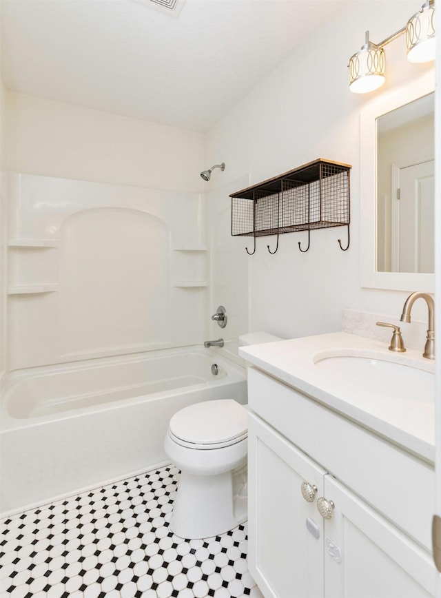 bathroom with washtub / shower combination, vanity, and toilet