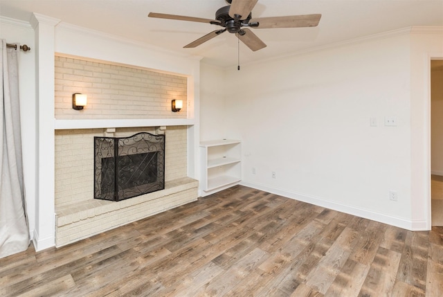 unfurnished living room with a fireplace, crown molding, baseboards, and wood finished floors