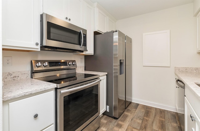 kitchen featuring baseboards, dark wood-style flooring, light stone countertops, stainless steel appliances, and white cabinetry