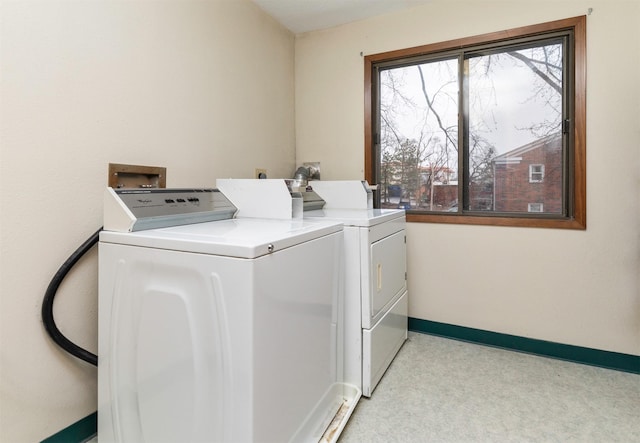 clothes washing area featuring baseboards, laundry area, and washer and dryer