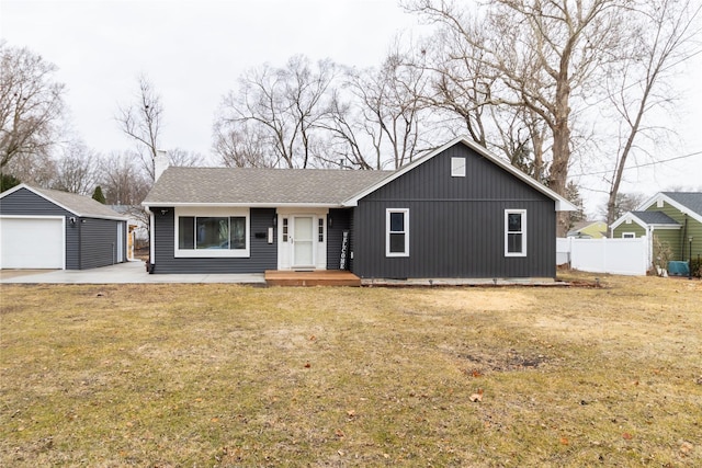 single story home with a detached garage, fence, a front lawn, and an outdoor structure