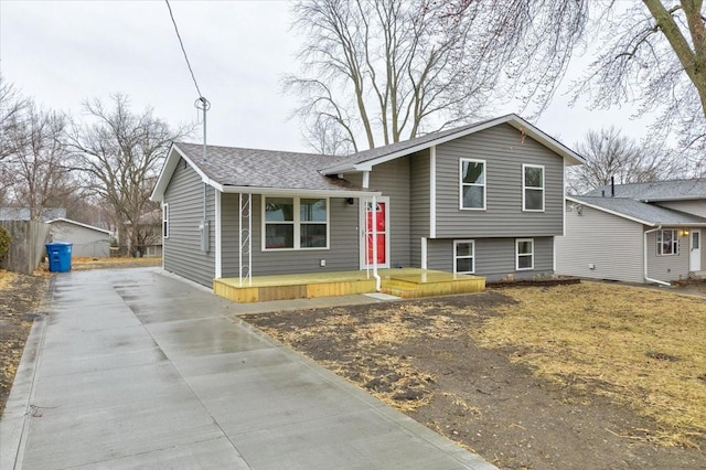 tri-level home with a shingled roof and driveway