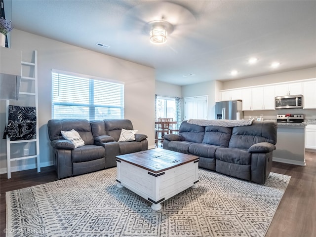 living room with baseboards, visible vents, dark wood-type flooring, and recessed lighting