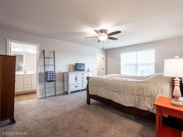 bedroom with a ceiling fan, carpet flooring, connected bathroom, and baseboards