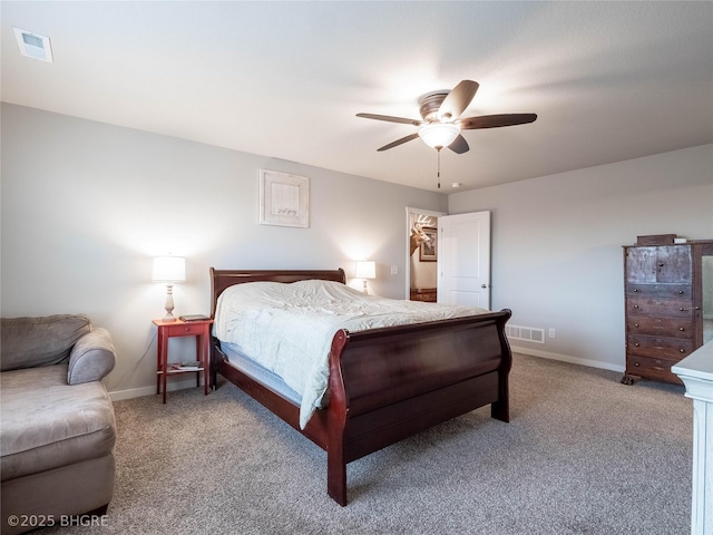 carpeted bedroom featuring a ceiling fan, visible vents, and baseboards