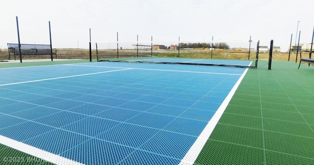 view of tennis court featuring fence