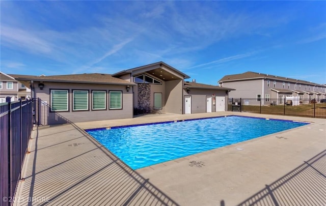 community pool with fence and a patio