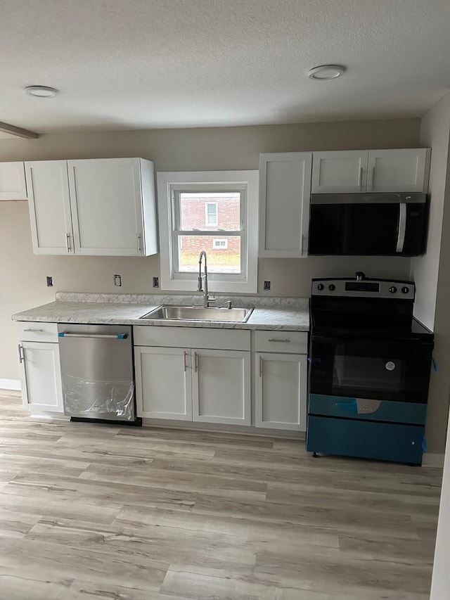 kitchen with white cabinetry, a textured ceiling, appliances with stainless steel finishes, and a sink