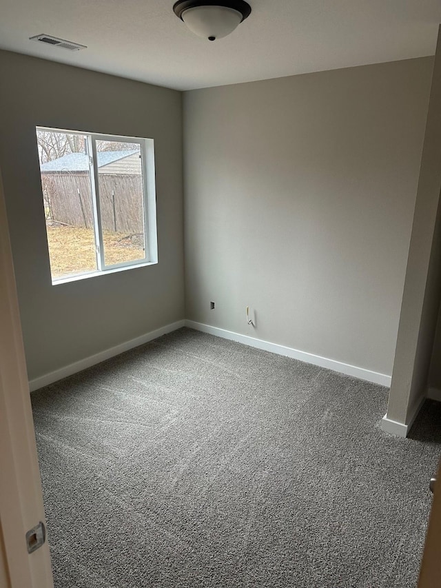 carpeted spare room with visible vents and baseboards