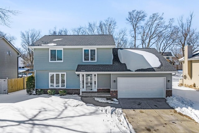 view of front facade with driveway, a shingled roof, an attached garage, fence, and brick siding