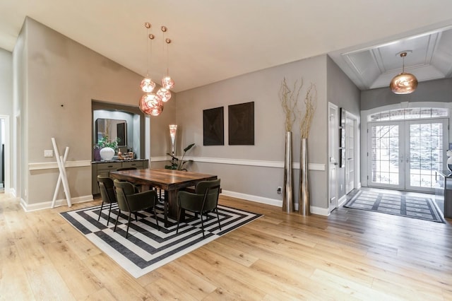 dining space with lofted ceiling, wood-type flooring, baseboards, and french doors