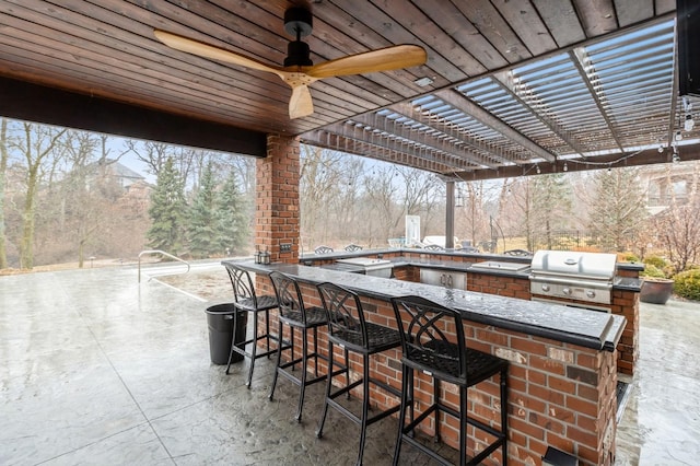 view of patio / terrace featuring exterior kitchen, outdoor wet bar, a grill, and a pergola