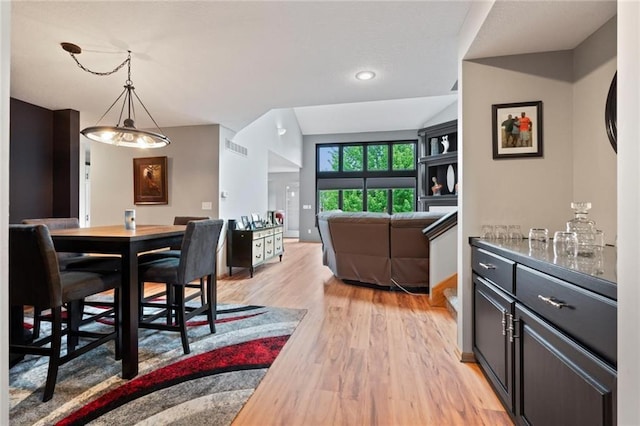 dining area featuring light wood-type flooring, visible vents, and baseboards