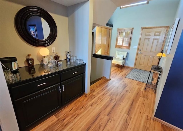 hall featuring light wood-type flooring and baseboards