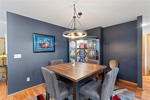 dining space featuring light wood-type flooring and baseboards