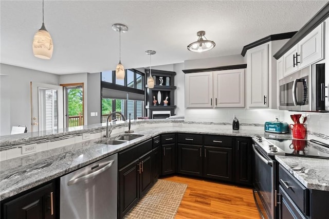 kitchen with appliances with stainless steel finishes, a sink, dark cabinetry, and white cabinetry