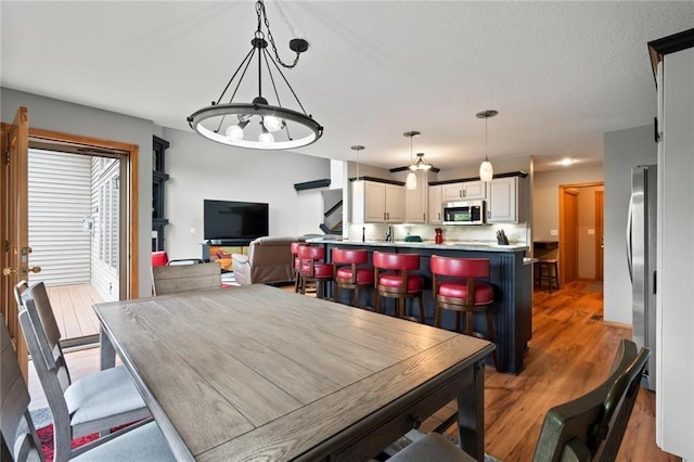 dining room with light wood-style flooring and a textured ceiling