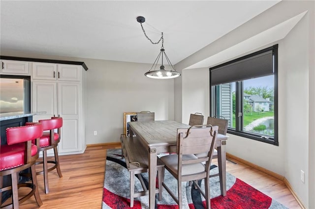 dining space featuring light wood-style flooring and baseboards