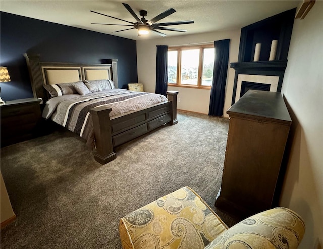 carpeted bedroom with ceiling fan and a tile fireplace