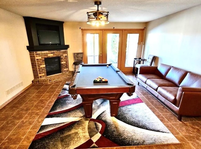 recreation room with a fireplace, visible vents, a textured ceiling, billiards, and tile patterned floors