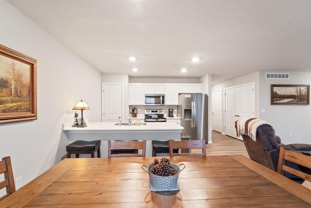 dining space featuring light wood-type flooring, visible vents, and recessed lighting