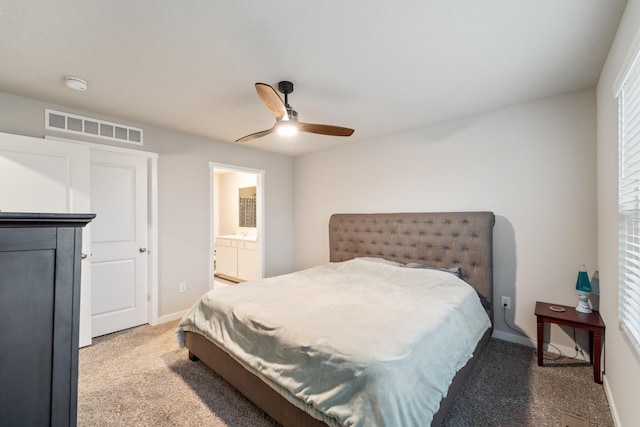 bedroom with light colored carpet, visible vents, ensuite bathroom, a ceiling fan, and baseboards